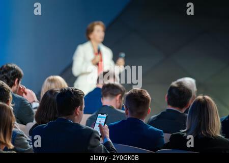 Les membres du public écoutant un orateur lors d'une conférence d'affaires. Personnes habillées professionnellement engagées dans une présentation formelle. Banque D'Images