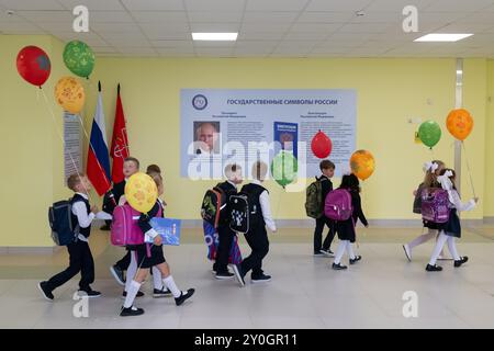 Pétersbourg, Russie. 02 septembre 2024. Des écoliers passent devant une affiche représentant le président russe Vladimir Poutine après la cérémonie de début d'année scolaire dans une école de Pétersbourg. Crédit : SOPA images Limited/Alamy Live News Banque D'Images