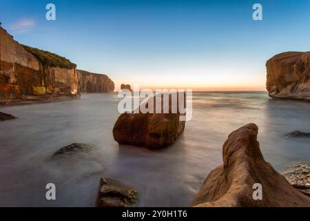 Aube à tunnel Beach, une plage populaire à la périphérie de Dunedin, à Otago, Nouvelle-Zélande. Banque D'Images