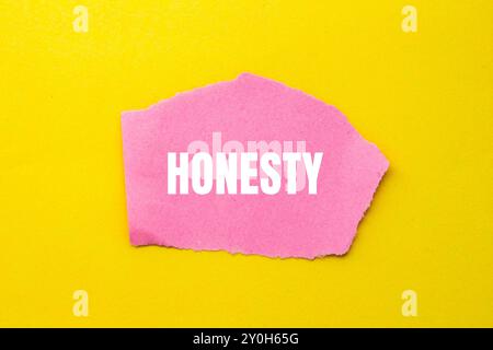 Message d'honnêteté écrit sur un morceau de papier rose déchiré déchiré avec fond jaune. Symbole d'honnêteté conceptuel. Copier l'espace. Banque D'Images