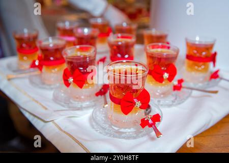Thé en verre armudu traditionnel azerbaïdjanais en forme de poire . Thé filtré pour l'engagement. fermé avec un ruban rouge . vérifier le noeud papillon . Thé noir turc i. Banque D'Images