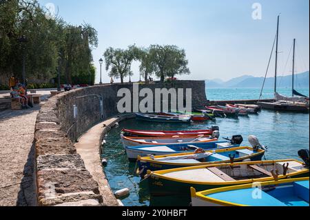 Vue pittoresque de bateaux colorés dans le port de Torri del Benaco sur la rive est du lac de Garde, Italie Banque D'Images