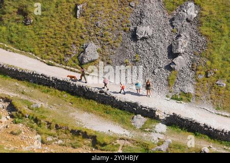 Touristes marchant le long d'un sentier pour Gordale Scar dans le parc national des Yorkshire Dales. Banque D'Images