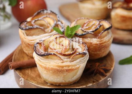 Roses de pomme fraîchement cuites avec menthe, cannelle et étoile d'anis sur la table lumineuse, gros plan Banque D'Images