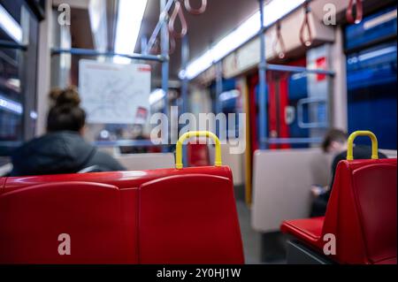 Vienne, Autriche, 23 août 2022. Plan conceptuel à l'intérieur du métro. Au premier plan, le siège rouge est pointu. En arrière-plan, les passagers sont flous Banque D'Images