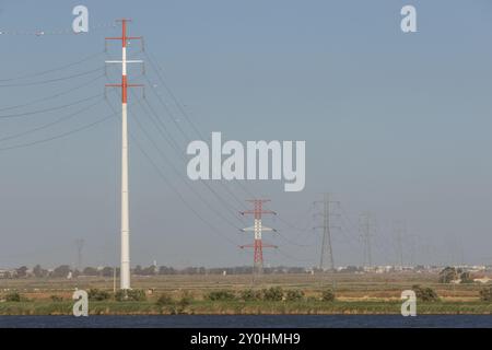 De grandes lignes électriques métalliques traversant un paysage rural, transportant l'électricité Banque D'Images