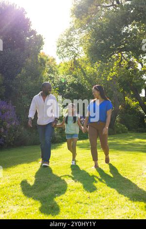 Marcher dans le parc, la famille profitant du temps en plein air ensemble le jour ensoleillé Banque D'Images