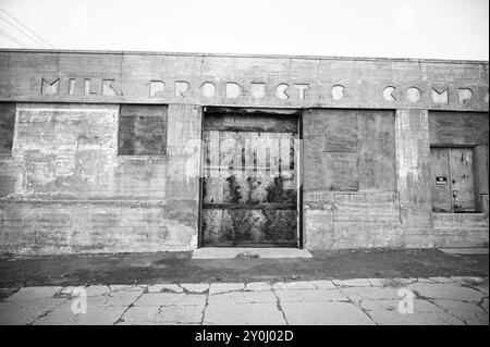 Un bâtiment industriel abandonné avec un lettrage art déco sur le devant. Ellensburg WA, États-Unis. Image en noir et blanc. Banque D'Images