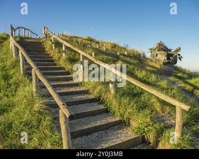 Escaliers en bois menant à une colline herbeuse avec un ciel bleu clair en arrière-plan, egmond aan Zee, pays-bas Banque D'Images