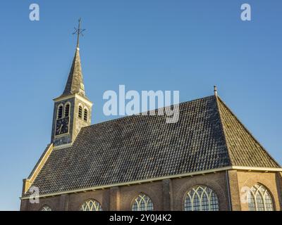 Église gothique avec toit en tuiles et grandes fenêtres, sous un ciel dégagé à la lumière du jour, egmond aan Zee, pays-bas Banque D'Images