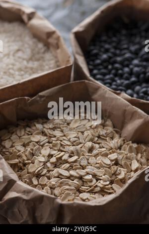 Un gros plan de trois différents types de grains, avoine, riz et haricots noirs Banque D'Images