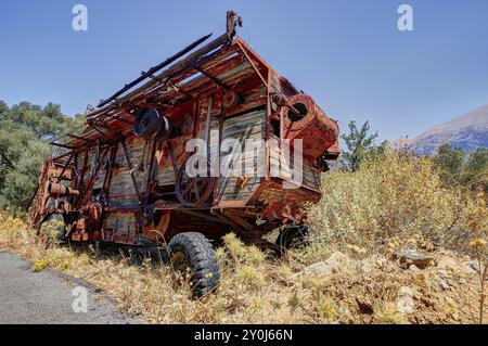 Moissonneuse-batteuse rouillée dans la zone rurale sur une route en été, véhicule naufragé, Crète, îles grecques, Grèce, Europe Banque D'Images