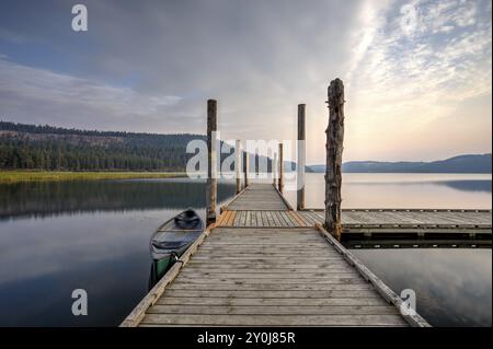 La lumière du matin sur le quai avec un canoë par elle sur le lac Chatcolet près de Plummer, Idaho Banque D'Images