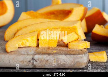 La citrouille orange mûre douce est coupée en tranches sur la table, en gros plan sur les parties de citrouille orange mûre Banque D'Images