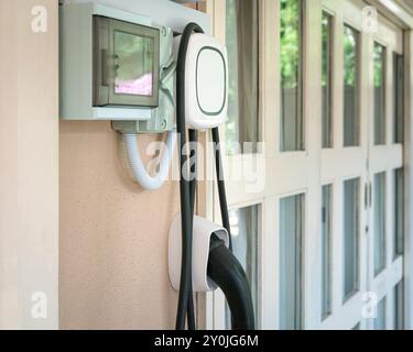 Borne de recharge murale pour voiture électrique installée dans une maison résidentielle. Banque D'Images