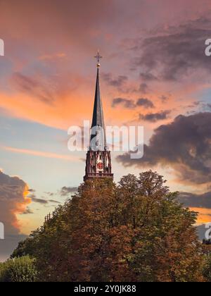 Le clocher de l'église évangélique des trois Rois à Francfort sous un ciel orange au coucher du soleil Banque D'Images