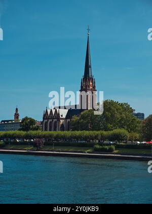 L'église évangélique des trois Rois à Francfort-sur-le-main avec un ciel dégagé et la rivière au premier plan Banque D'Images