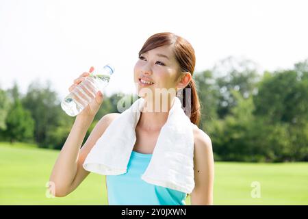 Femme de boire l'eau minérale Banque D'Images