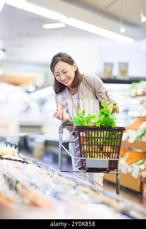 Femme souriante shopping dans le supermarché Banque D'Images