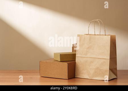 Sac en papier brun et boîtes en carton sur une surface en bois Banque D'Images