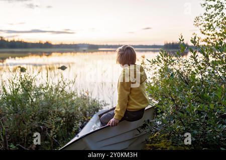 Enfants, jouer sur un bateau dans une rivière, l'été, regarder la nature avec des jumelles, temps ensoleillé l'été Banque D'Images