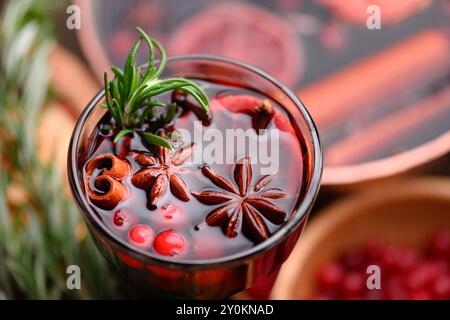 Boisson chaude de Noël - vin chaud dans un verre avec des bâtonnets de cannelle, canneberges étoilées en gros plan. Photographie culinaire Banque D'Images
