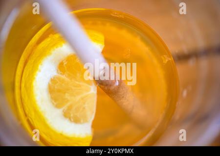 Une photo macro en gros plan capturant l'essence vibrante et rafraîchissante d'un cocktail garni d'une tranche de citron. Banque D'Images