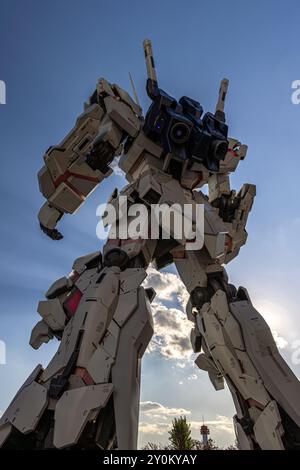 Robot géant debout avec ciel bleu et nuages en arrière-plan Banque D'Images