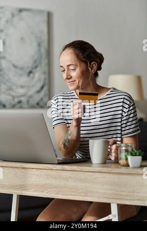 Une femme atteinte de vitiligo aime faire des achats en ligne avec une carte de crédit en main. Banque D'Images