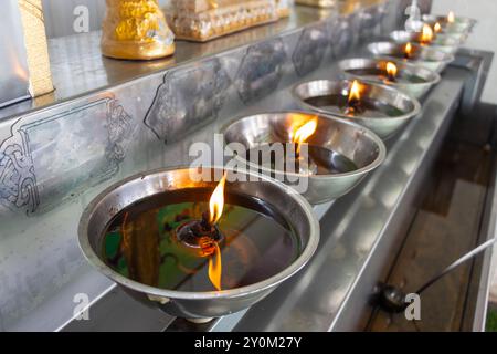 Une rangée de lampes à huile dans un temple bouddhiste Banque D'Images