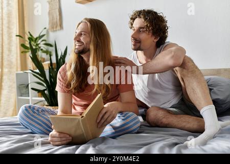 Un couple partage un moment tendre, lisant et profitant au lit. Banque D'Images