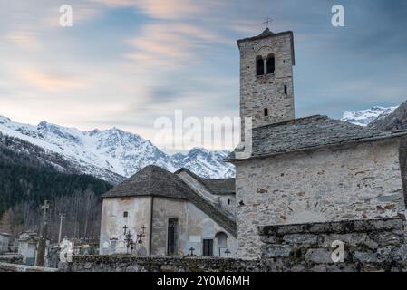 Vieille église de montagne en hiver, au coucher du soleil, dans les Alpes italiennes, Macugnaga et Monte Rosa en arrière-plan, vallée d'Anzasca, Italie Banque D'Images