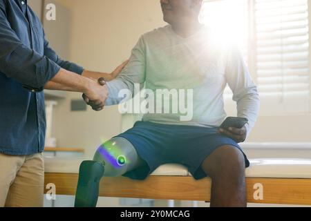 Homme avec une jambe prothétique serrant la main avec un thérapeute, tenant un smartphone Banque D'Images