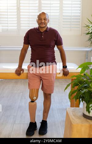 L'homme porteur d'une jambe prothétique debout en toute confiance dans une clinique médicale prothétique moderne Banque D'Images