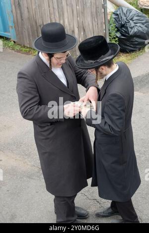 2 garçons juifs orthodoxes travaillant ensemble collectent des œuvres de charité, une bonne action mandatée, dans une synagogue du comté de Rickland, New York. Banque D'Images