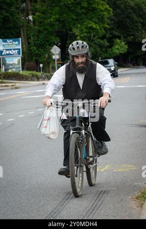 Un homme juif orthodoxe à vélo sur Orchard Street à MOnsey, Rockland County, New York. Banque D'Images