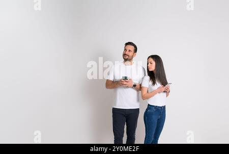 Femme suspecte espionnant dans le smartphone de petit ami discutant et regardant loin sur fond blanc Banque D'Images