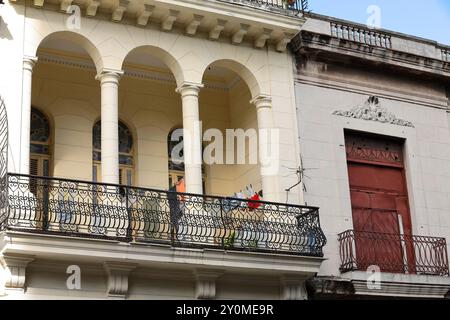 674 premier étage du début des années 1900 bâtiment de style éclectique sur 254 Paseo del Prado côté ouest, façade de couleur crème, séchage de linge sur balcon. La Havane-Cuba. Banque D'Images