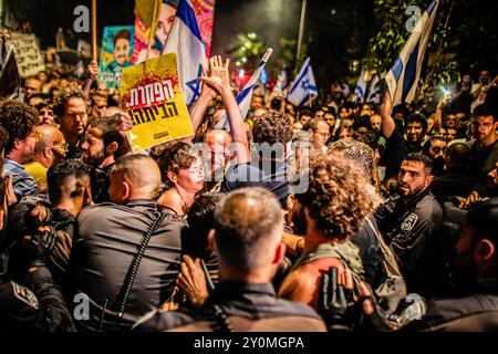 Les manifestants sont repoussés par des policiers israéliens lors d'une manifestation à la suite des funérailles de Hersh Goldberg Polin. Des dizaines de milliers de personnes se sont rassemblées à travers Israël pour la deuxième journée après que les corps de Carmel Gat, Eden Yerushalmi, Hersh Goldberg-Polin, Alexander Lobanov, Almog Sarusi et Maître Sgt Ori Danino aient été sauvés de Gaza. Les manifestants demandent au premier ministre Benjamin Netanyahu et à son gouvernement de conclure un accord pour obtenir la libération des otages restants pris par le Hamas lors des attaques du 7 octobre. Banque D'Images
