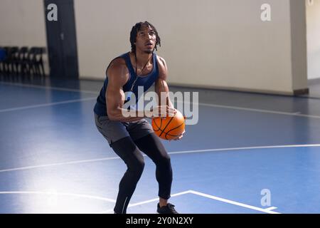 Jouant au basket-ball, homme se préparant à tirer la balle sur un terrain intérieur Banque D'Images