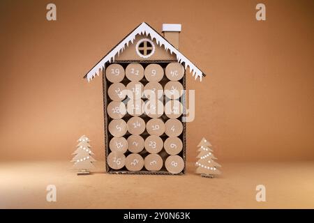 Maison de calendrier de l'AVENT en carton avec compartiments numérotés, artisanat fait à la main fabriqué à partir de rouleaux de papier toilette, concept de recyclage, décorations festives, sn Banque D'Images