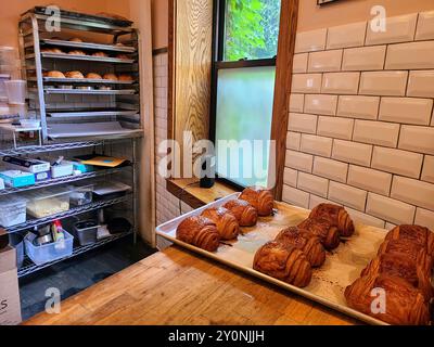 Croissants fraîchement cuits sur le comptoir en bois dans Cozy Bakery Kitchen vue au niveau des yeux Banque D'Images