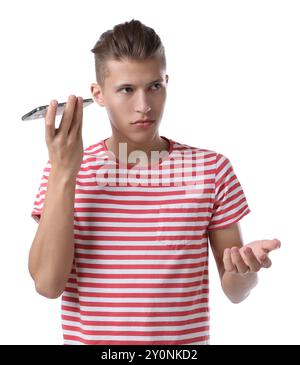 Jeune homme avec smartphone écoutant un message vocal sur fond blanc Banque D'Images