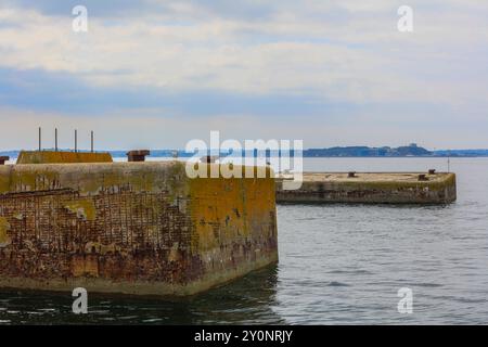 zwei von der deutschen Marine im zweiter Weltkrieg in der Bucht Rade de Brest vor der Halbinsel Plougastel-Daoulas gebauten Dalben, an denen das Schlachtschiff Bismarck anlegen sollte, hinten Marinestützpunkt strategische Atom-U-Boote Triomphant-Klasse der französischen Marine, Halbinsel Ile longue, Teil der Crozon-Halbinsel , Departement Finistere Departement Finistere Bistere Bredolische, au large de la baie de Frankreville de Pendolin the World-the-Brest, au cours de la bataille de la ville de la ville de la ville de Pendolphine, nucléaire stratégique de base navale arrière Banque D'Images