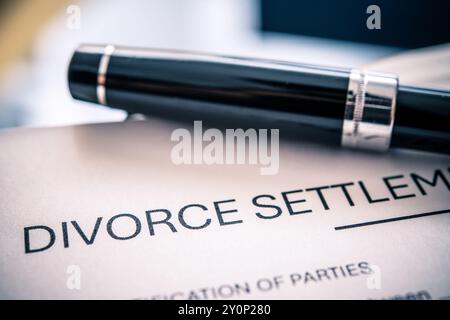 Un accord de règlement de divorce affiché en évidence avec un stylo noir élégant servant d'outil pour signer des documents juridiques liés à la séparation conjugale Banque D'Images