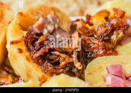 Boulette bouillie tranchée avec morceau de viande fumé saupoudrée d'oignon frit doré doux et croustillant, gros plan. Banque D'Images