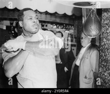 5 octobre 1956 : arrondissement londonien de Haringay, Londres, Royaume-Uni. ARCHIE MOORE, le champion du monde poids lourds légers qui rencontre Yolande Pompay à Harringay le 5 juin, vu au Tubies Gymnasium, Bermondsey, hier, en train de passer un coup au punch ball avant de descendre à Windsor pour prendre des quarts d’entraînement. (Image de crédit : © Keystone Press Agency/ZUMA Press Wire). UTILISATION ÉDITORIALE UNIQUEMENT ! Non destiné à UN USAGE commercial ! Banque D'Images