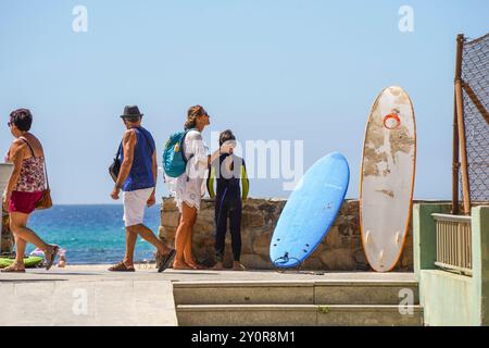 Surfeurs revenant de la plage de Tarifa, Andalousie, Espagne. Banque D'Images