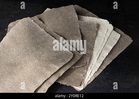 Gros plan de pages de papier lin faites à la main sur un fond sombre. Banque D'Images