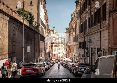 ROME, ITALIE - 14 JUIN 2024 : touristes sur un scooter électrique se déplaçant le long d'une rue étroite dans le centre historique de Rome entouré de vieux bâtiments de Banque D'Images